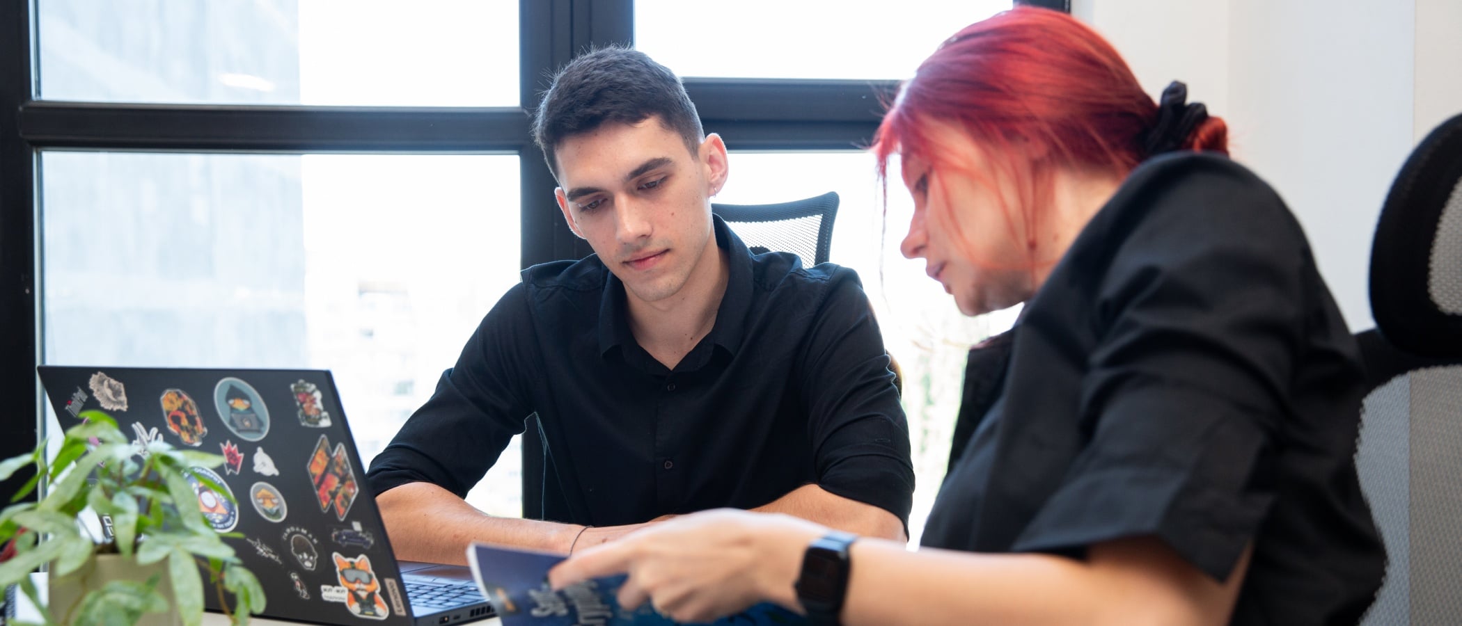 Colleagues discussing notes in the office