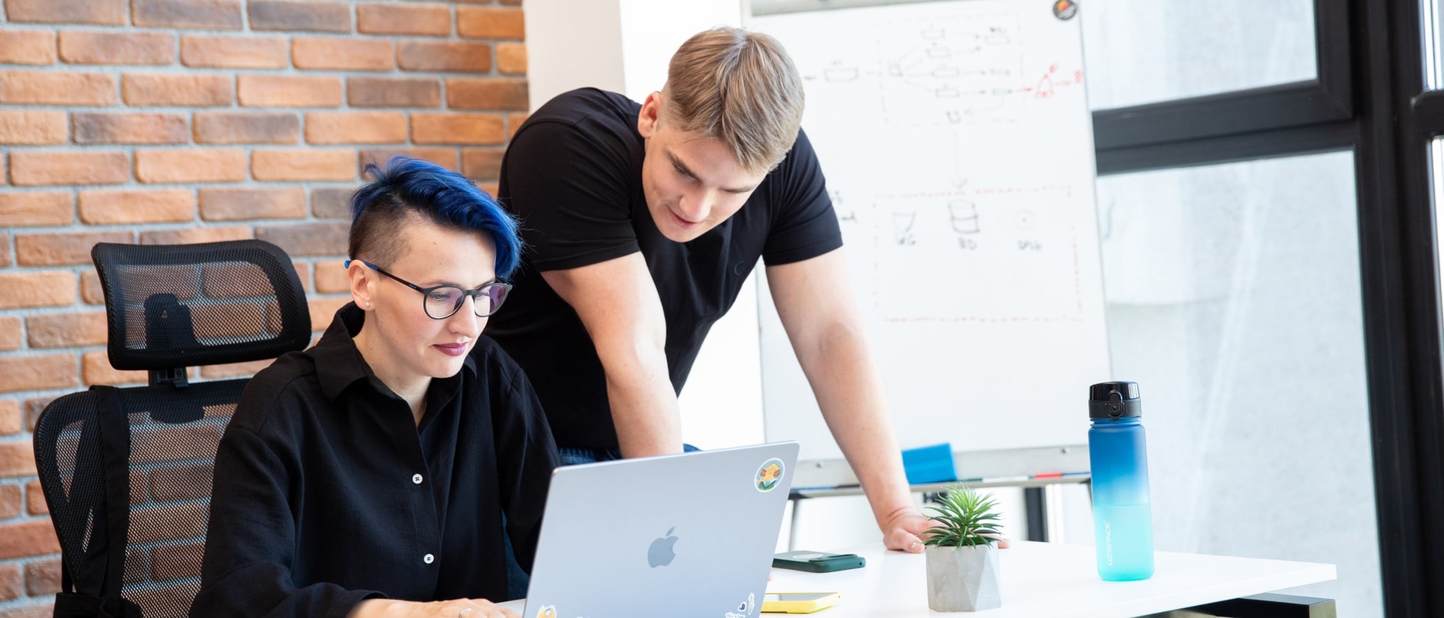 Project Manager collaborating with a colleague in the office